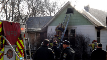 Manhattan firefighters attend to a house fire on 615 Yuma St. in Manhattan Friday just before noon. (Staff photo by Brady Bauman)