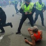 Boston Police attend to a fallen runner only seconds after one of the explosions.