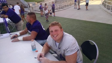 K-State's Ryan Mueller (right) and B.J. Finney sign autographs during Saturday's Fan Appreciation Day.