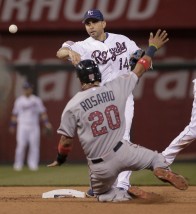 Kansas City Royals second baseman Omar Infante (14) throws to first for the double play hit into by Minnesota Twins' Miguel Sano after forcing out Eddie Rosario (20) at second during the eighth inning of a baseball game Saturday, July 4, 2015, in Kansas City, Mo. (AP Photo/Charlie Riedel)