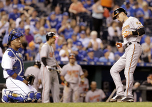 Baltimore Orioles' Ryan Flaherty, right, crosses the plate in front of Kansas City Royals catcher Salvador Perez after hitting a solo home run during the ninth inning of a baseball game Wednesday, Aug. 26, 2015, in Kansas City, Mo. (AP Photo/Charlie Riedel)