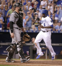 Kansas City Royals' Lorenzo Cain, right, runs past Chicago White Sox catcher Tyler Flowers to score on a single by Eric Hosmer during the sixth inning of a baseball game Friday, Aug. 7, 2015, in Kansas City, Mo. (AP Photo/Charlie Riedel)