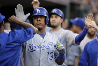 Kansas City Royals' Salvador Perez (13) is congratulated by teammates after he and Eric Hosmer scored on Perez's two-run home run off Detroit Tigers starting pitcher Justin Verlander during the fourth inning of a baseball game, Tuesday, Aug. 4, 2015, in Detroit. (AP Photo/Carlos Osorio)
