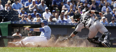 Kansas City Royals' Alex Rios beats the tag by Chicago White Sox catcher Geovany Soto to score the go-ahead run on a fielders choice hit into by Omar Infante during the eighth inning of a baseball game, Sunday, Aug. 9, 2015, in Kansas City, Mo. (AP Photo/Charlie Riedel)
