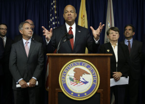 United States Secretary of Homeland Security Jeh Johnson, center, speaks during a news conference in Newark, N.J., Tuesday, Aug. 11, 2015. An international group of hackers and stock traders made $30 million by breaking into the computers of newswire services that put out corporate press releases and trading on the information before it was made public, federal prosecutors said Tuesday. (AP Photo/Seth Wenig)