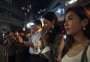 Mew, 33, from Bangkok, second from right, prays at Erawan Shrine, the site of Monday's deadly bombing, at Rajprasong intersection in Bangkok, Thailand, Wednesday, Aug. 19, 2015. The central Bangkok shrine reopened Wednesday to the public after Monday's bomb blast as authorities searched for a man seen in a grainy security video who they say was the prime suspect in an attack authorities called the worst in the country's history. (AP Photo/Karly Domb Sadof)