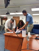 USD 383 Board of Education President Marcia Rozell and KNEA Chair James Neff make the board/teacher negotiated agreement official, with Assistant Superintendent Eric Reid (right). Photo Credit: Aaron Estabrook