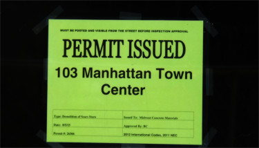 A demolition permit on the window of a door near the entrance of the closed Sears auto center. (Staff photo by Brady Bauman)