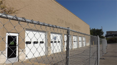 Fencing surrounds the old Sears auto care center at the Manhattan Town Center. The wing of the mall is set to be demolished and a new IMAX theater will take its place. (Staff photo by Brady Bauman)