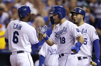 Kansas City Royals center fielder Lorenzo Cain (6) is congratulated by teammates Ben Zobrist (18) and Eric Hosmer, right, after hitting a three-run home run during the second inning of a baseball game against the Detroit Tigers at Kauffman Stadium in Kansas City, Mo., Thursday, Sept. 3, 2015. (AP Photo/Orlin Wagner)