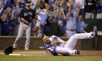 Kansas City Royals' Paulo Orlando celebrates after scoring the game-winning run on a single by Lorenzo Cain during the 10th inning of a baseball game against the Seattle Mariners Wednesday, Sept. 23, 2015, in Kansas City, Mo. The Royals won 4-3. (AP Photo/Charlie Riedel)