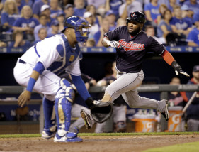 Cleveland Indians' Abraham Almonte runs past Kansas City Royals catcher Salvador Perez to score on a single by Jason Kipnis during the sixth inning of a baseball game Saturday, Sept. 26, 2015, in Kansas City, Mo. (AP Photo/Charlie Riedel)