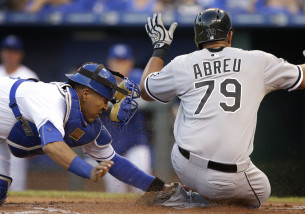 Chicago White Sox' Jose Abreu (79) beats the tag by Kansas City Royals catcher Salvador Perez during the first inning of a baseball game at Kauffman Stadium in Kansas City, Mo., Friday, Sept. 4, 2015. Abreu scored on a hit by teammate Avisail Garcia. (AP Photo/Orlin Wagner)