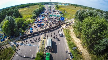 This picture taken by a drone shows the stranded migrants at the border station between Serbia and Hungary near Horgos, Serbia, Wednesday, Sept. 16, 2015. Small groups of migrants continued to sneak into Hungary on Wednesday, a day after the country sealed its border with Serbia and began arresting people trying to breach the razor-wire barrier, while a first group arrived in Croatia seeking another way into the European Union. (Istvan Ruzsa/MTI via AP)