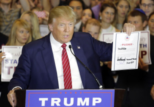 Republican presidential candidate Donald Trump holds a signed pledge during a news conference in Trump Tower, Thursday, Sept. 3, 2015 in New York. Trump ruled out the prospect of a third-party White House bid and vowed to support the Republican Party's nominee, whoever it may be. (AP Photo/Mark Lennihan)