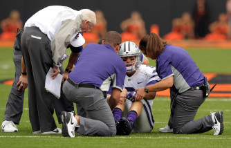 Kansas State head coach Bill Snyder, left, talks with starting quarterback Joe Hubener, center, while medical personnel examine the quarterback during the first quarter of an NCAA football game in Stillwater, Okla.,Saturday, Oct. 3, 2015. (AP Photo/Brody Schmidt)