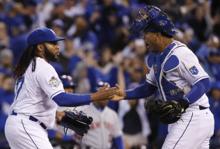 Kansas City Royals catcher Salvador Perez, right, congratulates starting pitcher Johnny Cueto at the end of Game 2 of the Major League Baseball World Series against the New York Mets Wednesday, Oct. 28, 2015, in Kansas City, Mo. The Royals defeated the Mets 7-1 to take at two game lead in the series.  (AP Photo/Matt Slocum)