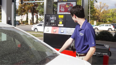 K-State senior Asher Gilliland, a major in finance, puts gas in his car Friday afternoon at the Kwik Shop across from campus. Regular unleaded gasoline was priced at $2.29 per gallon. (Staff photo by Brady Bauman)
