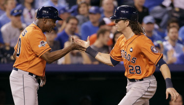 Houston Astros' Colby Rasmus celebrates with third base coach Gary Pettis, left, after hitting a solo home run during the eighth inning in Game 1 of baseball's American League Division Series against the Kansas City Royals, Thursday, Oct. 8, 2015, in Kansas City, Mo. (AP Photo/Charlie Riedel)