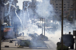 Israeli troops fire tear gas during clashes with Palestinian demonstrators near Ramallah, West Bank, Friday, Oct. 16, 2015. Tensions and violence have been mounting in recent weeks, in part fueled by Palestinian fears that Israel is trying to expand its presence at a major Muslim-run shrine in Jerusalem, a claim Israel has denied. (AP Photo/Majdi Mohammed)