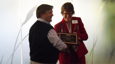 Sunset Zoo Director Scott Shoemaker accepts a plaque from Association of Zoos and Aquariums Executive Director Kris Vehrs Thursday evening in the Nature Exploration Center. (Staff photo by Brady Bauman)