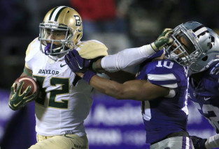 Baylor running back Shock Linwood (32) stiff-arms Kansas State defensive back Donnie Starks (10) during the second half of an NCAA college football game in Manhattan, Kan., Thursday, Nov. 5, 2015. Baylor defeated Kansas State 31-24. (AP Photo/Orlin Wagner)