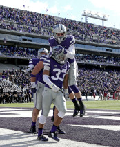 Kansas State defensive back Morgan Burns (33) celebrates with teammates after a returning a kick off 100 yards for a touchdown during the first half of an NCAA college football game against Iowa State Saturday, Nov. 21, 2015, in Manhattan, Kan. (AP Photo/Charlie Riedel)