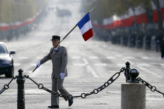 French military official carrying the French flag arrives at the Arc de Triomphe during the Armistice Day ceremonies marking the end of World War I, in Paris, France, Wednesday, Nov. 11, 2015. The Armistice Day is commemorated every year on Nov. 11 to mark the armistice signed between the allies of World War I and Germany to end the war. (AP Photo/Francois Mori)