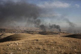 Smoke rises over Sinjar, northern Iraq from oil fires set by Islamic State militants as Kurdish Iraqi fighters, backed by U.S.-led airstrikes, launch a major assault on Thursday, Nov. 12, 2015. The strategic town of Sinjar was overran last year  by the Islamic State group in an onslaught that caused the flight of tens of thousands of Yazidis and first prompted the United States to launch the air campaign against the militants. (AP Photo/Bram Janssen)