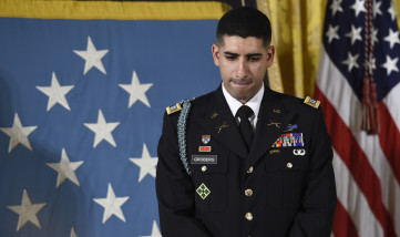 Medal of Honor recipient retired U.S. Army Capt. Florent Groberg, listens as President Barack Obama speaks about his actions during combat operations in Afghanistan, Thursday, Nov. 12, 2015, during a ceremony in the East Room of the White House in Washington. (AP Photo/Susan Walsh)