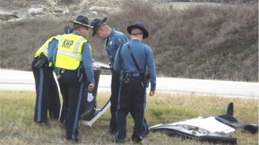 Highway Patrol officers survey wreckage.