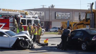 Emergency crews work on cleaning up the damage left by a four-vehicle accident at the intersection of Fort Riley Boulevard and Fourth Street Friday in Manhattan. (Staff photos by Brady Bauman)