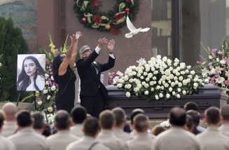 The parents Yvette Velasco release a dove of during a memorial service on Thursday, Dec. 10, 2015 in Covina, Calif. Velasco died in a mass shooting in San Bernardino, Calif., that killed 14 and injured 21 last Wednesday. (AP Photo/Chris Carlson)