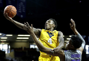 West Virginia's Daxter Miles Jr. (4) gets past Kansas State's Wesley Iwundu to put up a shot during the first half of an NCAA college basketball game, Saturday, Jan. 2, 2016, in Manhattan, Kan. (AP Photo/Charlie Riedel)