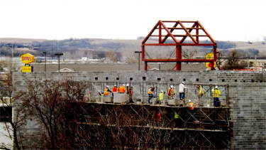 Construction crews work on one of the walls of the new IMAX movie theater at Manhattan Town Center Saturday afternoon. (Staff photos by Brady Bauman) 