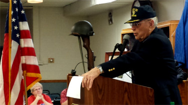 Manhattan resident Jim Sharp, an Army staff sergeant who had fought in the Battle of the Bulge and was wounded during World War II, speaks to the crowd during Saturday morning's 71st anniversary of the battle inside the Manhattan American Legion building. Sharp is also a noted author and historian. (Staff photos by Brady Bauman)