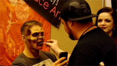 A attendee of Manhattan's first Little Apple Comic Con gets his face painted at a booth in the Manhattan Conference Center. 