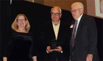 Rod Harms, middle, poses with the 2015 C. Clyde Jones Volunteer of the Year Award Friday night during the Manhattan Area Chamber of Commerce's 91st Annual Meeting and Banquet inside the Manhattan Conference Center.