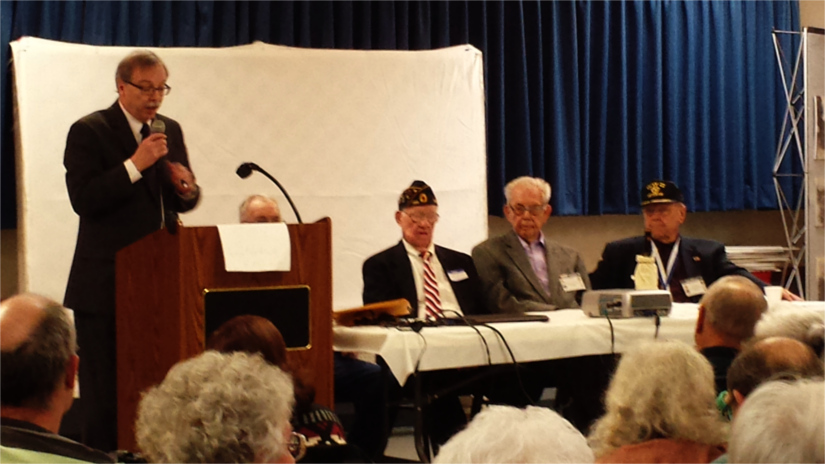 Bob Smith, the director of museums at Fort Riley, moderates a panel of World War II veterans Saturday morning in the Manhattan American Legion. 