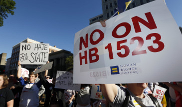 Protesters call for Mississippi Gov. Phil Bryant to veto House Bill 1523, which they say allow discrimination against LGBT people, during a rally outside the Governor's Mansion in Jackson, Miss., Monday, April 4, 2016. (AP Photo/Rogelio V. Solis)