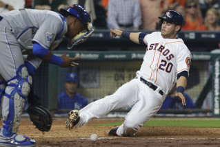 Houston Astros' Preston Tucker (20) slides into home plate to score as Kansas City Royals catcher Salvador Perez reaches for the ball in the fourth inning of a baseball game Monday, April 11, 2016, in Houston. Tucker scored on a Luis Valbuena double. (AP Photo/Pat Sullivan)