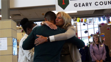 Second Lady of the United States, Dr. Jill Biden, hugs a Fort Riley Middle School student who helped hold Biden's welcome sign to the school.