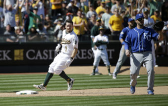 Oakland Athletics' Billy Burns (1) is safe at third base with a triple past Kansas City Royals third baseman Mike Moustakas, right, during the eighth inning of a baseball game Sunday, April 17, 2016, in Oakland, Calif. (AP Photo/Marcio Jose Sanchez)