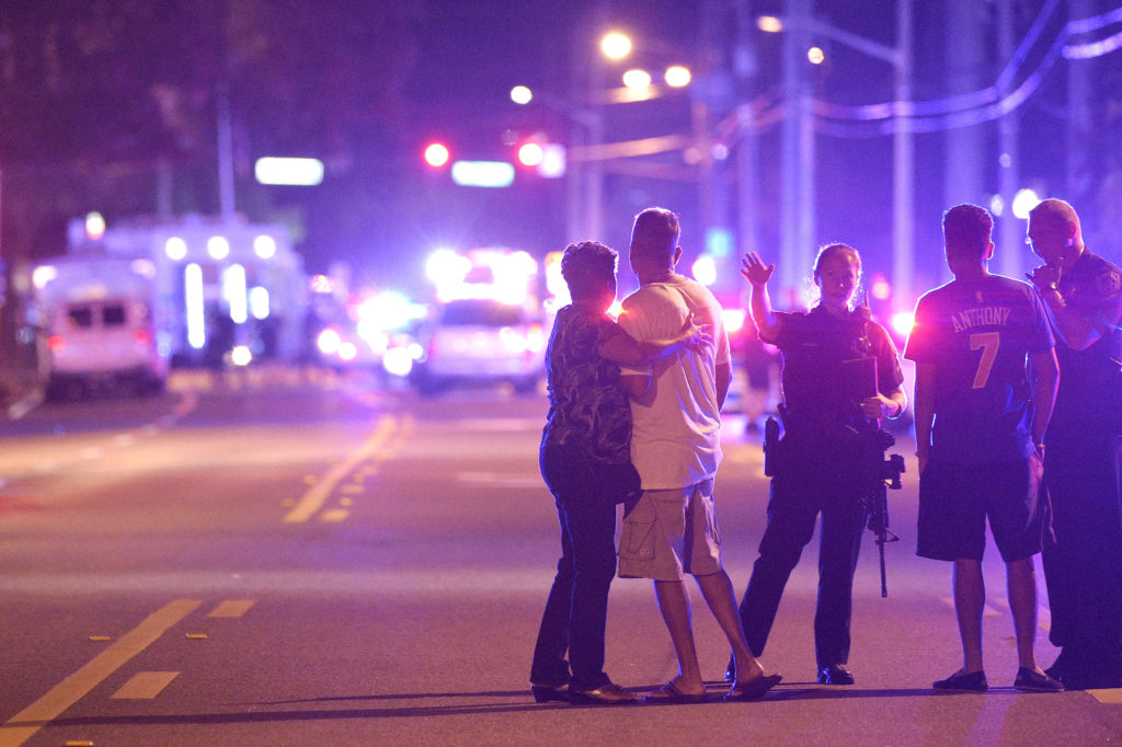 Orlando Police officers direct family members away from a fatal shooting at Pulse Orlando nightclub in Orlando, Fla., Sunday, June 12, 2016. (AP Photo/Phelan M. Ebenhack)