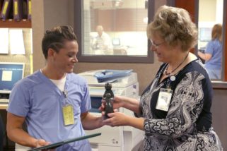 Jennifer Goehring, Assistant Chief Nursing Officer and Administrator-Operations, presents Jessi Erickson, RN, with the DAISY Award trophy on July 21. Jessi, who is from Wamego, has worked at the hospital since 2005.