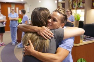 Jessi Erickson, RN, hugs her former patient, Carly Suther, after receiving the DAISY Award for exceptional nursing. Suther and her daughter, Hailey, 7 weeks, attended the brief ceremony.