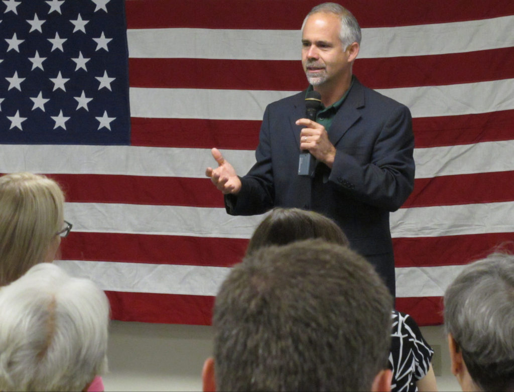 In this July 25, 2016 photo, U.S. Rep. Tim Huelskamp, R-Kan., speaks during a campaign town hall meeting at the headquarters of Patriot Outfitters, which sells firearms, accessories and hunting and military gear in St. Marys, Kan. Huelskamp is locked in a tough GOP primary race against Roger Marshall, a Great Bend obstetrician. (AP Photo/John Hanna)