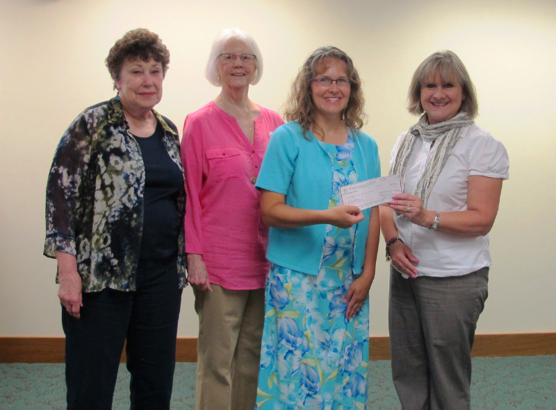 Photo by Judy Regehr; PEO IW PCE Committee members Marcia Schuley, Candace Pannbacker, and Chair Cathy Scroggs presenting check to Jennifer Hasenbank