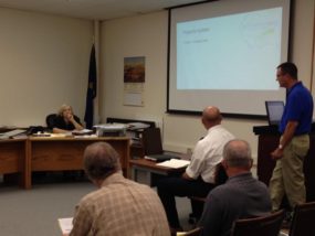 Pottawatomie County Public Works Asst. Dir. Jim Jenkins (standing), Director Peter Clark (seated) addressing Pottawatomie County Commissioners Monday (Commission Chair Dee McKee in the photo)