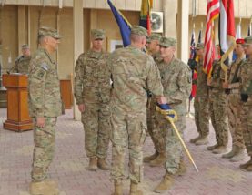 The 101st Airborne Division senior noncommissioned officer, Command Sgt. Maj. Gregory Nowak, passes the Combined Joint Forces Land Component Command - Operation Inherent Resolve colors to Maj. Gen. Gary Volesky, outgoing commanding general, CJFLCC-OIR, during the Transfer of Authority ceremony Nov. 17 in Baghdad, Iraq. The ceremony marked the end of the 101st Abn. Div.'s nine-month deployment and officially transferred authority of the CJFLCC-OIR mission to Maj. Gen. Joseph Martin, 1st Infantry Division and Fort Riley commanding general. (Spc. Anna Pongo, 1st Inf. Div. Public Affairs)